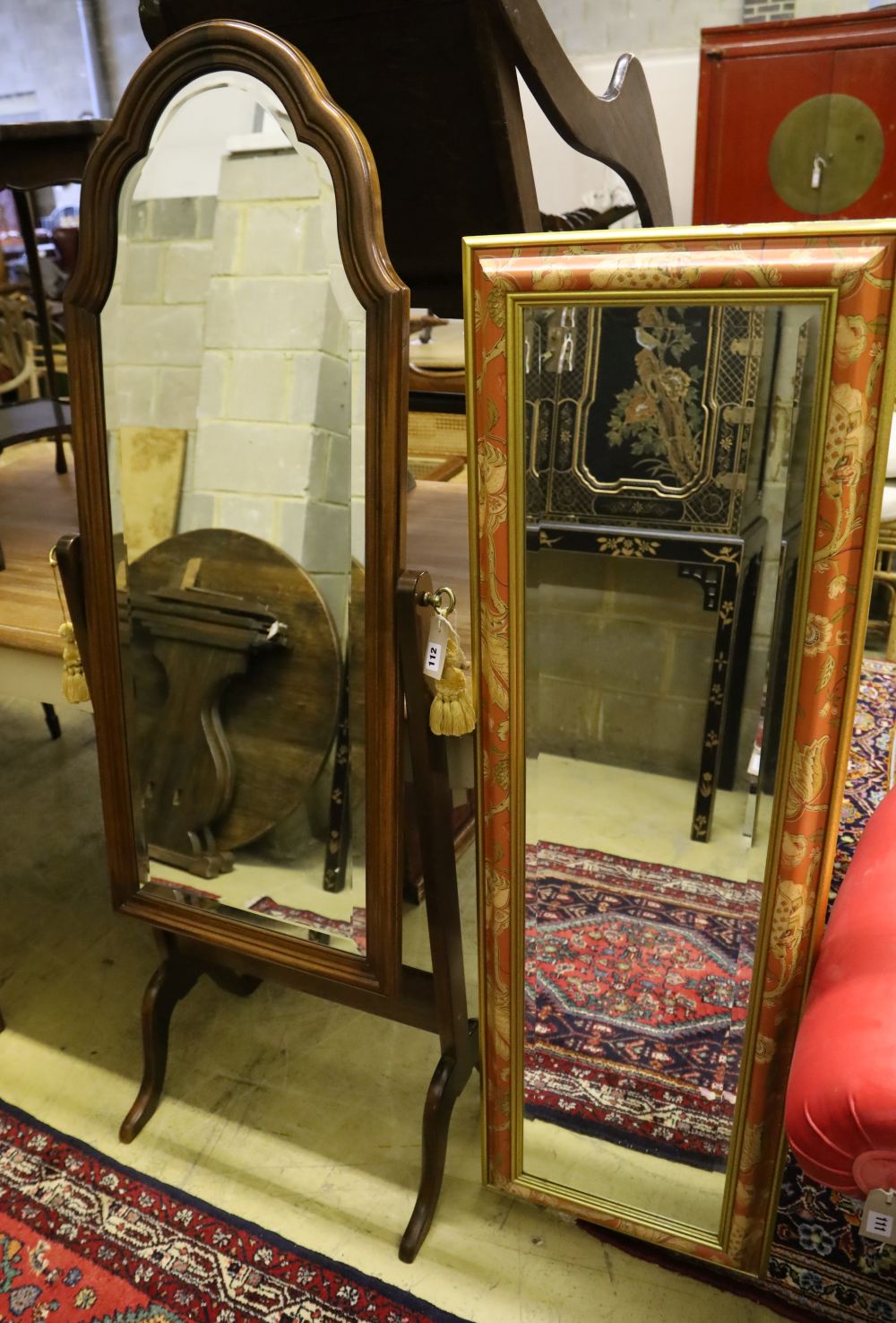 A modern mahogany cheval mirror with shaped top, 160cm high and a rectangular wall mirror with decorative frame